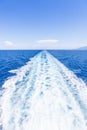 Wake of water from a boat, open sea with horizon and blue sky Royalty Free Stock Photo