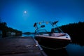 A wakeboard boat docked on Lake Joseph in the evening with the moon in the background. Royalty Free Stock Photo