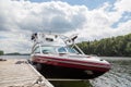 A wakeboard boat at a wooden dock in the Muskokas on a sunny day. Royalty Free Stock Photo