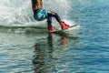 Wakeboarder jumps from a springboard behind a rope and makes a wave on the water Royalty Free Stock Photo