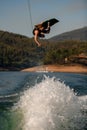 wakeboarder makes dangerous stunts jumping and flips on wakeboard over splashing river wave Royalty Free Stock Photo