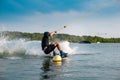 Wakeboarder making grab of board maneuvering between buoys