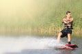 Wakeboarder trains in the lake at sunny day. Space for text Royalty Free Stock Photo
