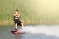 Wakeboarder trains in the lake at sunny day. Space for text Royalty Free Stock Photo