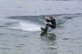 Wakeboarding with a guide mechanism. An unknown athlete holds on to the cable, performing tricks in the direction of travel