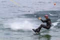 Wakeboarding with a guide mechanism. An unknown athlete holds on to the cable, performing tricks in the direction of travel