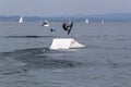 Wakeboarding with a guide mechanism. An unknown athlete holds on to the cable, performing tricks on the water trampoline