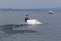 Wakeboarding with a guide mechanism. An unknown athlete holds on to the cable, performing tricks on the water trampoline