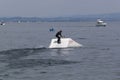 Wakeboarding with a guide mechanism. An unknown athlete holds on to the cable, performing tricks on the water trampoline