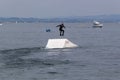 Wakeboarding with a guide mechanism. An unknown athlete holds on to the cable, performing tricks on the water trampoline