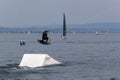 Wakeboarding with a guide mechanism. An unknown athlete holds on to the cable, performing tricks on the water trampoline