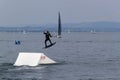 Wakeboarding with a guide mechanism. An unknown athlete holds on to the cable, performing tricks on the water trampoline