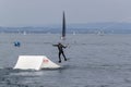 Wakeboarding with a guide mechanism. An unknown athlete holds on to the cable, performing tricks on the water trampoline