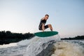 Wakesurfer riding down the river on a blue board Royalty Free Stock Photo