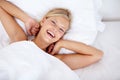 Waking up with a smile. High-angle view of a beautiful woman lying in bed and smiling at the camera. Royalty Free Stock Photo
