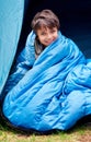 Waking up to a fresh new day...camping rocks. Portrait of a young boy wrapped in his sleeping bag. Royalty Free Stock Photo