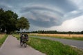 Walbeck, North Rine-Westphalia, Germany - Trekking bike at a country road with a hugh cumulus rain cloud in the background Royalty Free Stock Photo