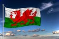 Wales national flag waving in the wind against deep blue sky. International relations concept