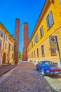 Walk along narrow medieval street to outstanding towers on Piazza Leonardo da Vinci, on April 9 in Pavia, Italy Royalty Free Stock Photo