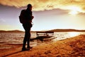 Walk along sea. Man with backpack walk on beach at rusty pedal boat. Autumn at sea. Royalty Free Stock Photo