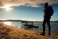 Walk along sea. Man with backpack walk on beach at rusty pedal boat. Autumn at sea. Royalty Free Stock Photo