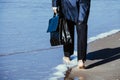 Walk bare foot beach sea man feet trousers raincoat feet briefcase bag blue water sky reflection Royalty Free Stock Photo