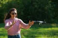 Walk with a drone. Young woman in black glasses launches a low flying drone. Reaches out to low flying drone, catches.