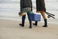 Walk, fishing and men on beach together with cooler, tackle box and holiday adventure. Ocean, fisherman and friends with Royalty Free Stock Photo