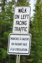 A walk on left facing traffic sign in both english and french