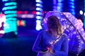 Walk through the night rainy city with an umbrella and lights. Creative photo