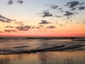 Walk by the ocean, at sunset. Silhouettes and magnificent orange-pink sky