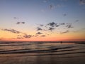 Walk by the ocean, at sunset. Silhouettes and magnificent orange-pink sky