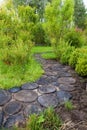 Walk path in garden decorated with wooden stumps. Royalty Free Stock Photo