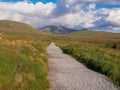 Walk path into mountains, Connemara National park, Ireland, Sunny warm day, Cloudy sky Royalty Free Stock Photo