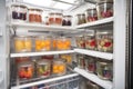 walk-in refrigerator filled with stackable plastic containers for easy storage of food