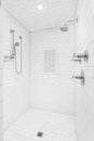 A walk-in shower with white subway tiles and chrome showerhead.