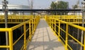 Walk way with yellow handrail inside factory