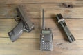 A walkie-talkie, a gun and a flashlight on a wooden table. Devices for the game stalker. Weapons and military equipment.