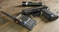 A walkie-talkie, a gun and a flashlight on a wooden table. Weapons and military equipment. Devices for the game stalker.