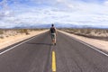 Walking alone on a lone desert highway Royalty Free Stock Photo