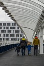 Walking along a bridge holding hands with young children