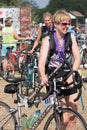 Walking back her car after a triathlon carrying a floor pump Royalty Free Stock Photo