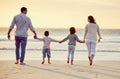 Walking, beach and back of family holding hands on holiday, summer vacation and weekend at sunset. Nature, travel and Royalty Free Stock Photo