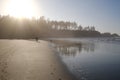 Walking on the beach with his dog in the late afternoon sun