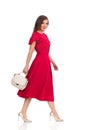 Walking Beautiful Woman In Elegant Red Dress, Gold High Heels And Beige Purse Royalty Free Stock Photo