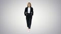 Walking businesswoman with hands in pockets on gradient backgrou Royalty Free Stock Photo