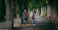 Walking cheerful young couple by the hand along the archway of Centennial Hall in Wroclaw, Poland overgrown with plants. Royalty Free Stock Photo