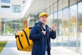 Walking courier delivery man asian smiling and looking at camera, has a big yellow backpack for food delivery Royalty Free Stock Photo