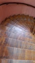 Old wooden spiral staircase with ornate railings and shabby steps