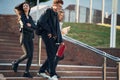 Walking down the stairs. Three young students are outside the university outdoors Royalty Free Stock Photo